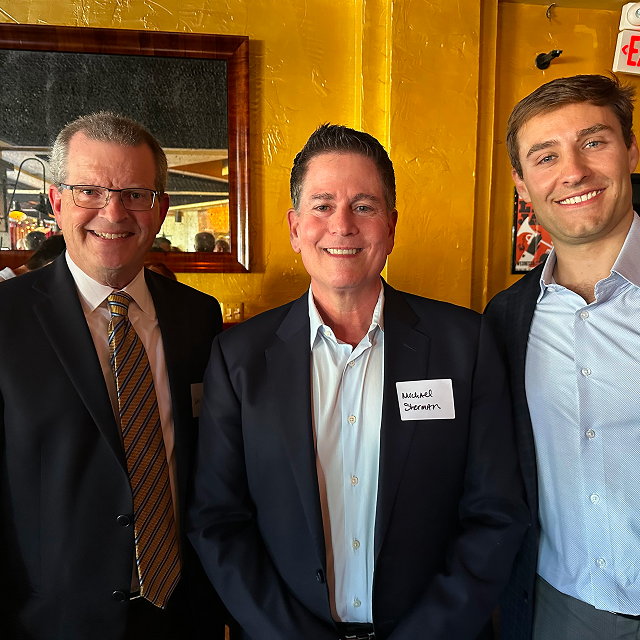 Three attendees posing together for a photo during a residency celebration dinner