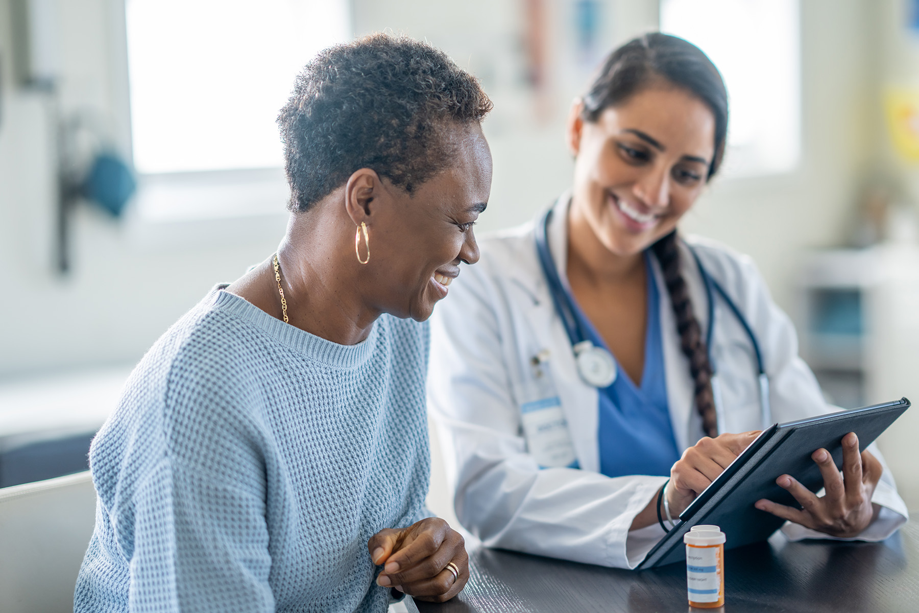 Female patient and female doctor smiling while looking at something