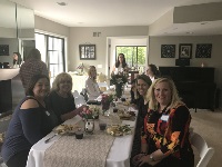 A group of women engaged in discussion at a table in a room, representing Graduate Medical Education in Southeast Michigan.