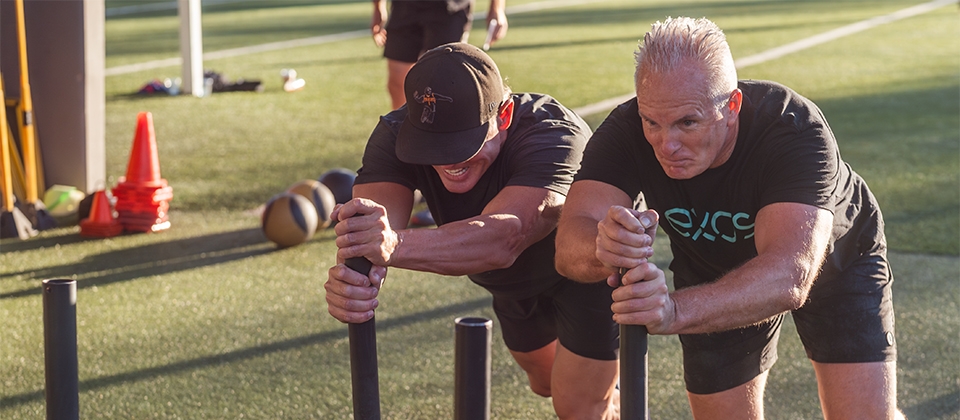 Two men exercising on a field, highlighting their commitment to fitness in an open-air location.
