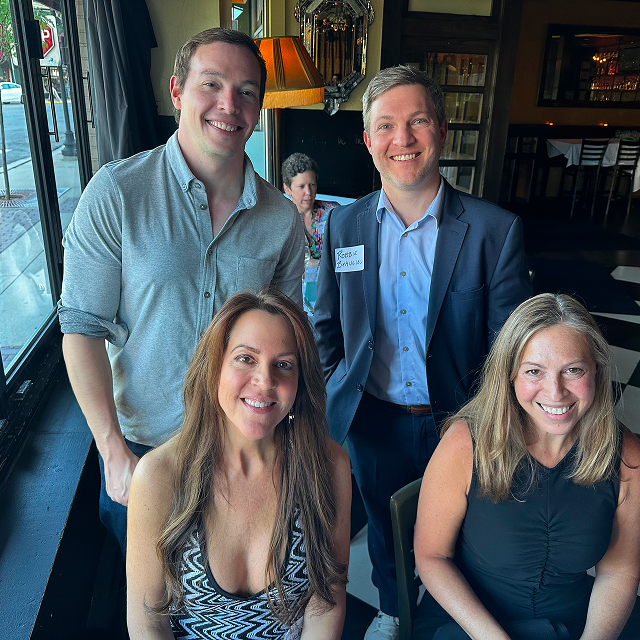 Four alumni attendees posing together during a residency celebration event