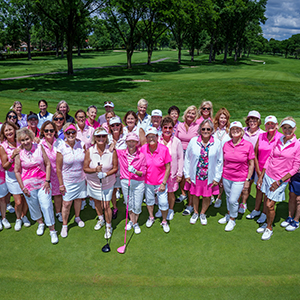 group of female golfers wearing pink and white