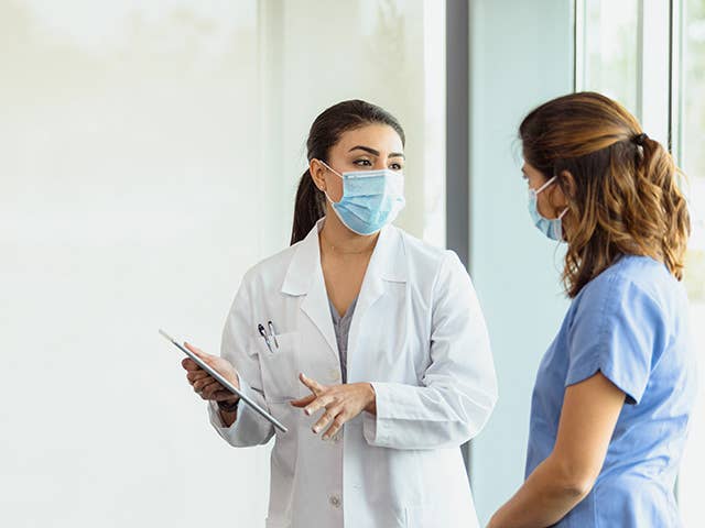 Two healthcare providers talking.