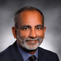 Surender Rajasekaran, MD, an Indian man in a suit and tie, serves as Research Director at ICPD and Medical Director at Corewell Health.