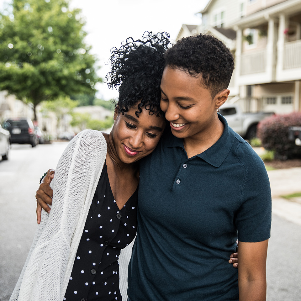 Two smiling Black women hug