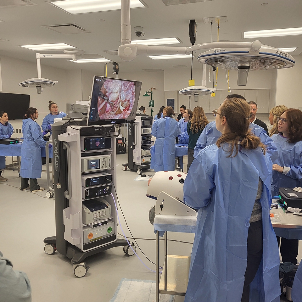 A group of health care professionals gathered in a room around medical equipment.