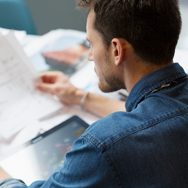 White male with dark hair looking at documents at a table