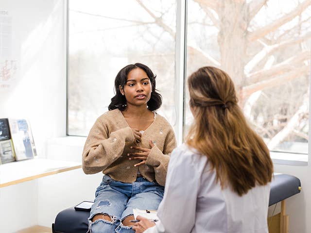 Teenage girl talking to a medical professional about her feelings and symptoms.