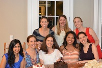 A group of women celebrating at a table with a cake, representing Graduate Medical Education in Southeast Michigan.