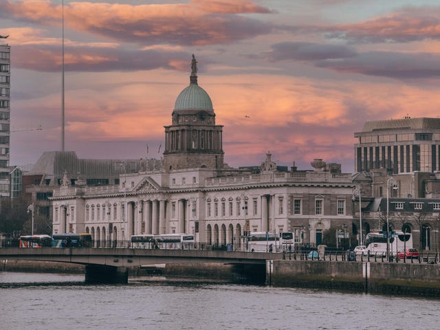 Vista aérea de Dublin com pontes e prédios no pôr-do-sol.