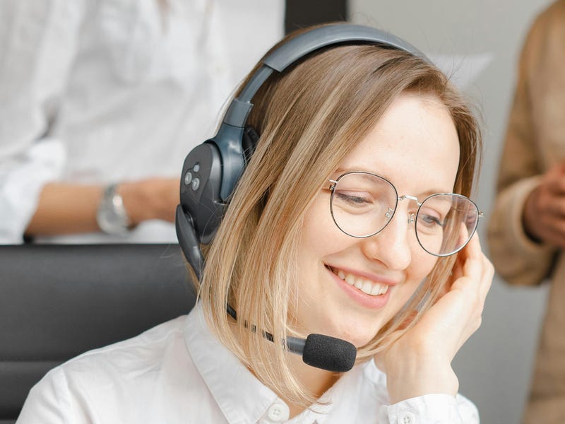 Mulher da área do atendimento ao cliente sorrindo.
