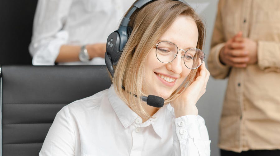 Mulher da área do atendimento ao cliente sorrindo.