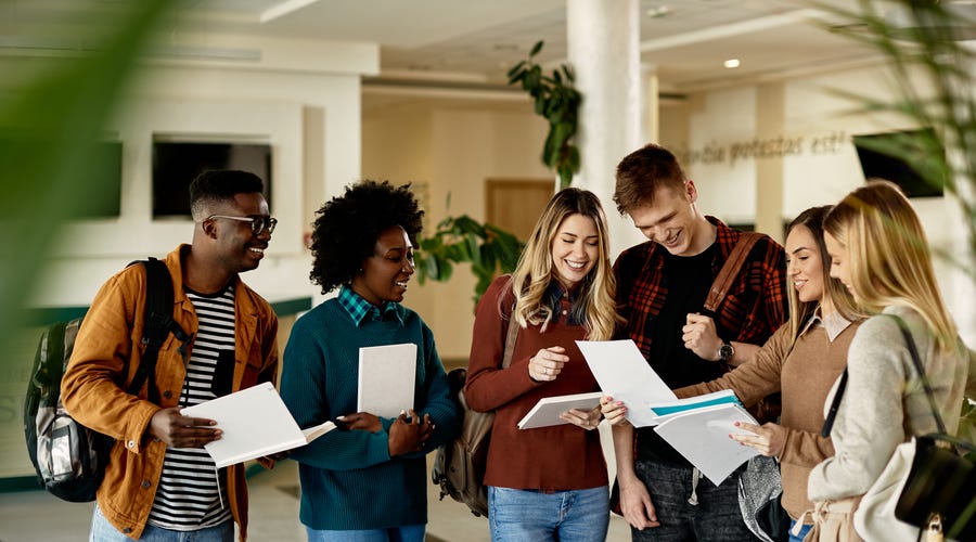 Grupo de jovens acabando de fazer uma prova de certificação de proficiência em inglês.