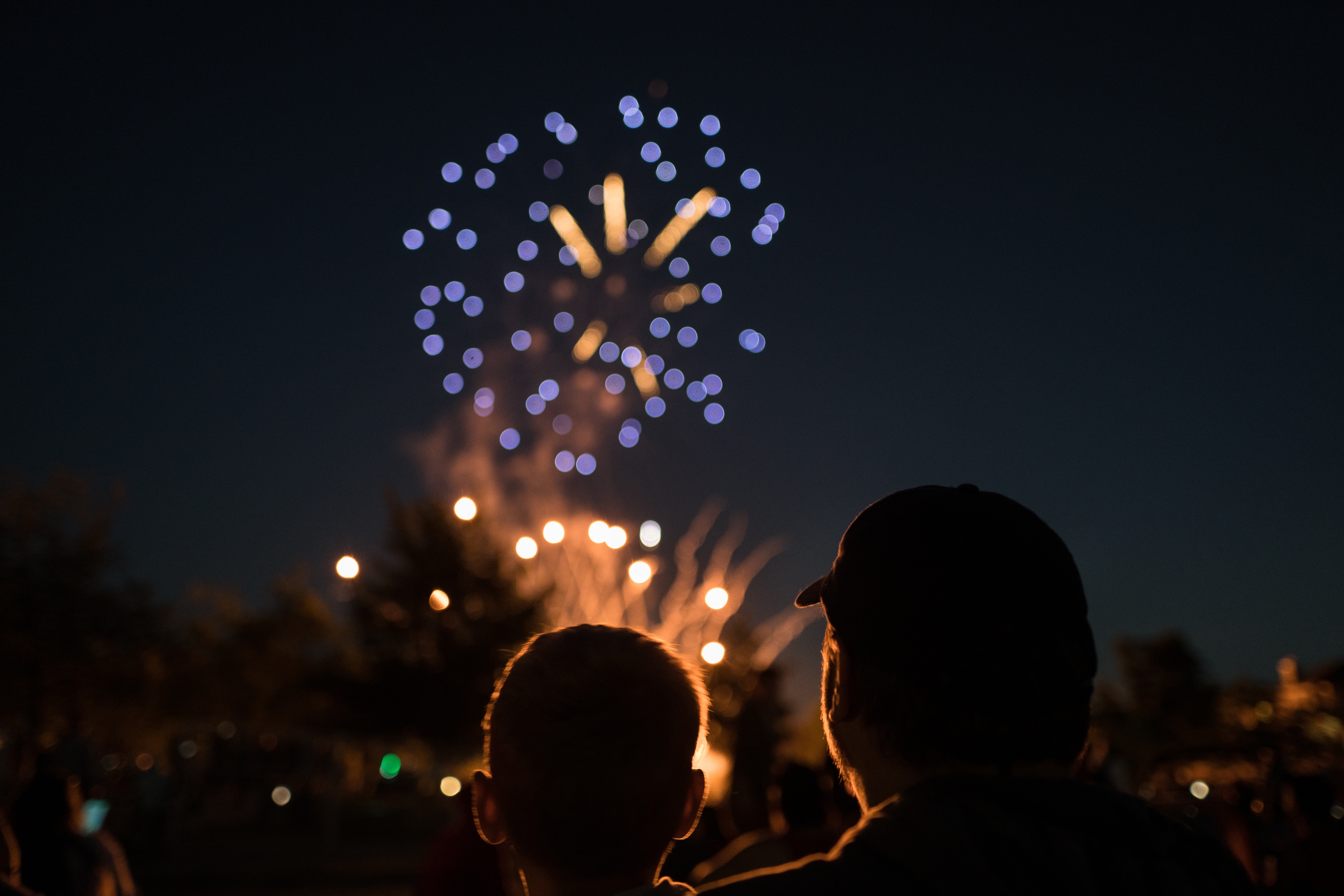 Um homem e uma criança assistindo aos fogos de artifício em comemoração ao 4 de Julho.