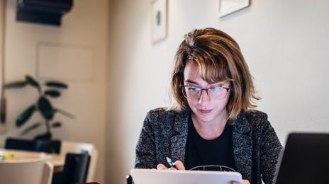 Mulher faz curso de idiomas online em casa pelo computador.