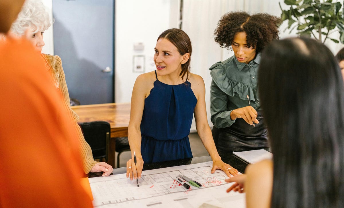 Equipe trabalhando em um projeto de arquitetura com colaboração de todos os integrantes.