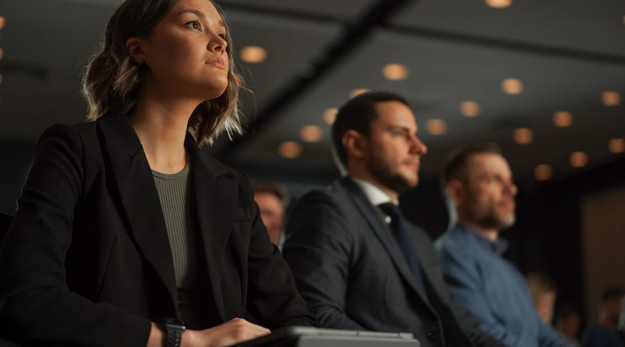 Pessoas assistindo a uma conferência de inglês