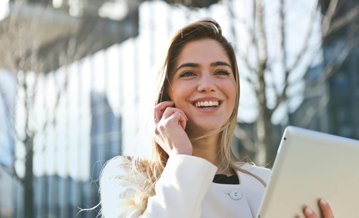 Mulher estudando pelo celular para o exame Telc B1 de alemão.
