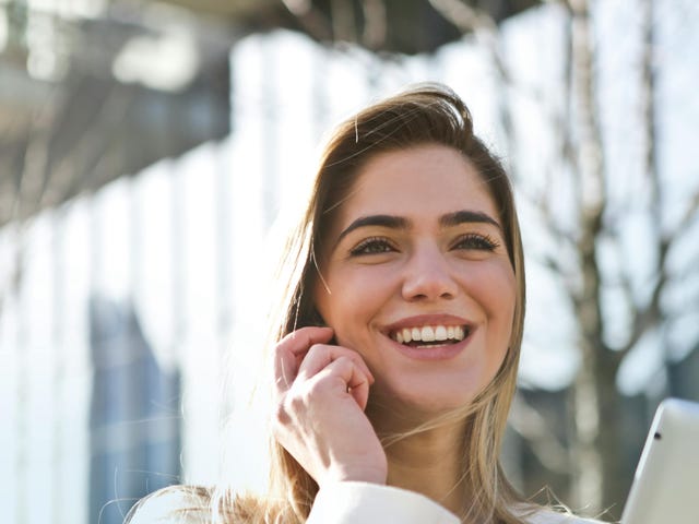Mulher estudando pelo celular para o exame Telc B1 de alemão.