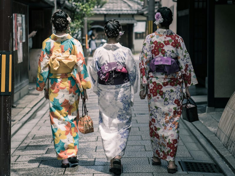 Mulheres em trajes tradicionais a caminho de um dos feriados no Japão.