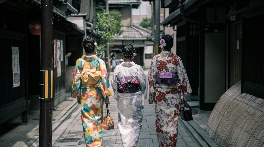 Mulheres em trajes tradicionais a caminho de um dos feriados no Japão.