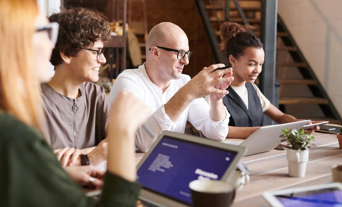 Equipe debatendo sobre conscientização cultural durante uma reunião.