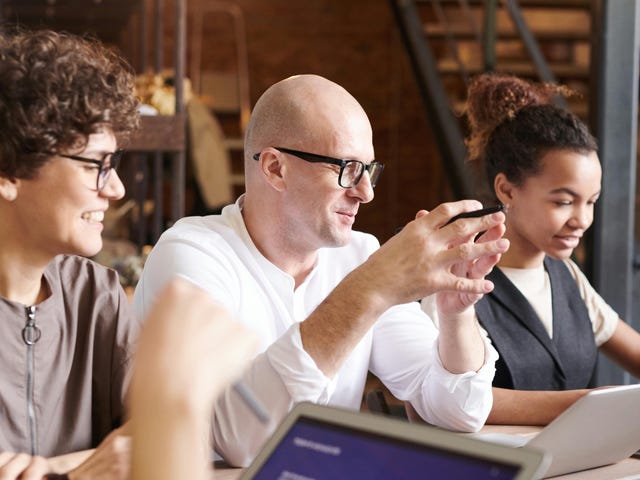 Equipe debatendo sobre conscientização cultural durante uma reunião.