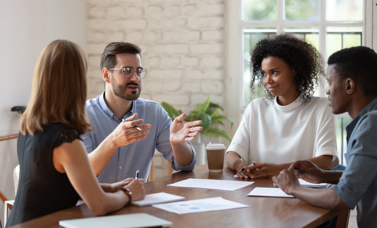 Homem conversando com duas mulheres sobre os cursos de hard e soft skills do Berlitz