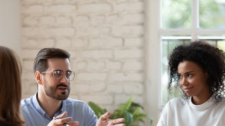 Homem conversando com duas mulheres sobre os cursos de hard e soft skills do Berlitz