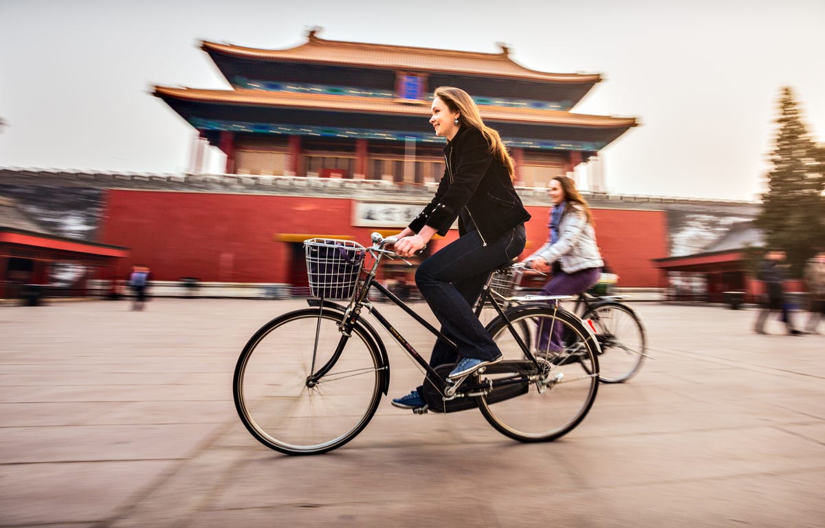 Mulheres passeiam em Pequim após aprender mandarim no Berlitz.