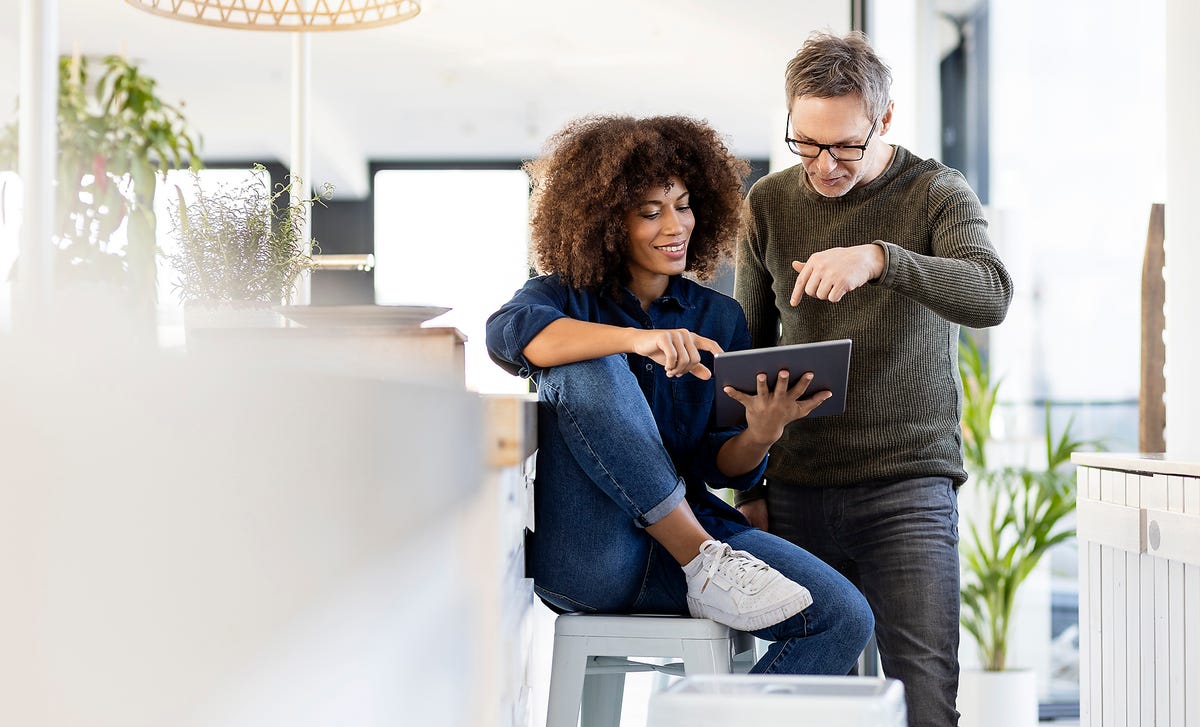 Um rapaz mostrando para uma moça como fazer a rematrícula na Berlitz.