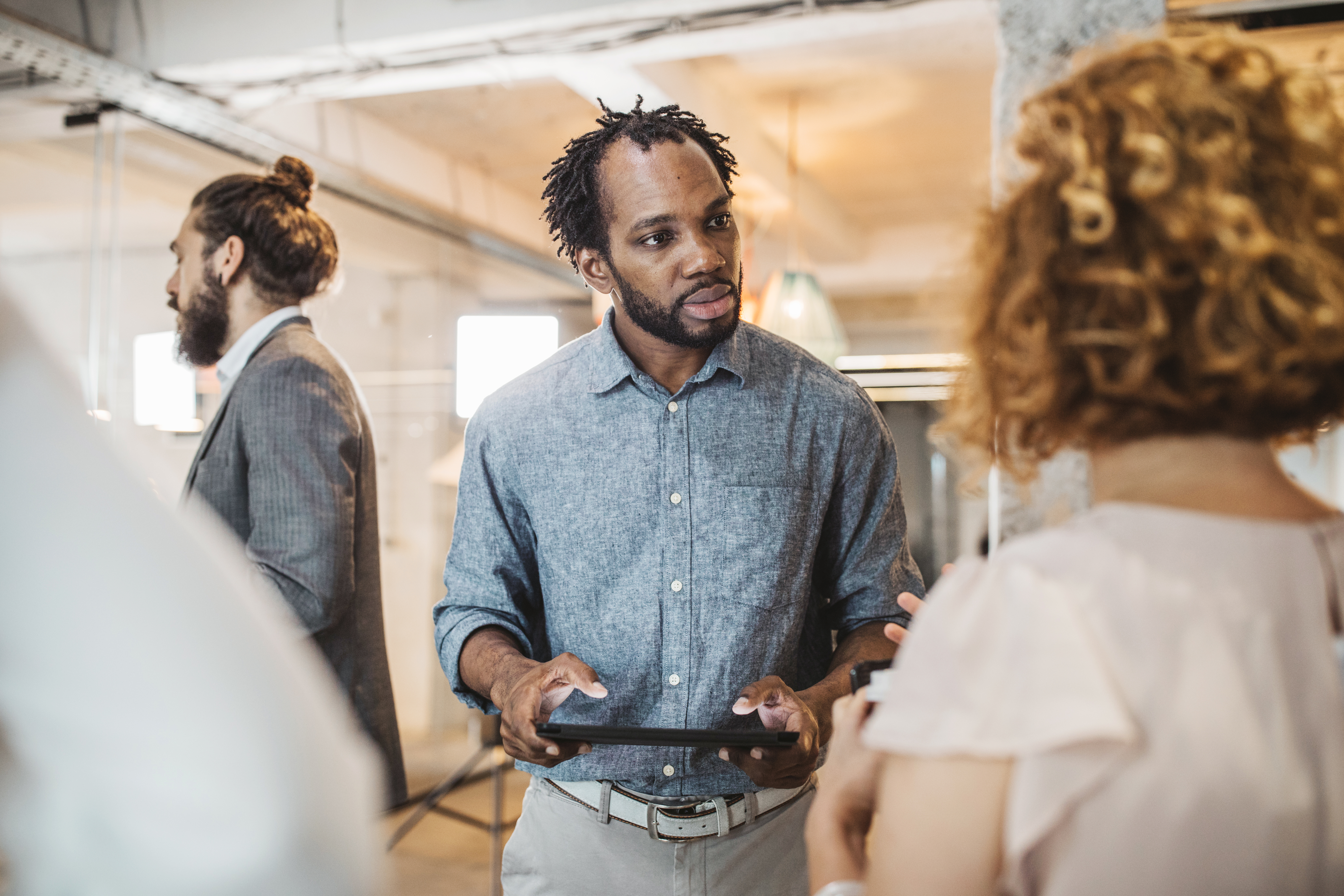 Homem negro em uma aula de conversação para se preparar para o exame Telc a2 de alemão.