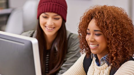 Jovens estudam juntas com curso de romeno online.