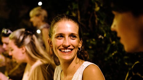 Jovem estudante em um jantar com seus colegas de intercambio na Austrália.