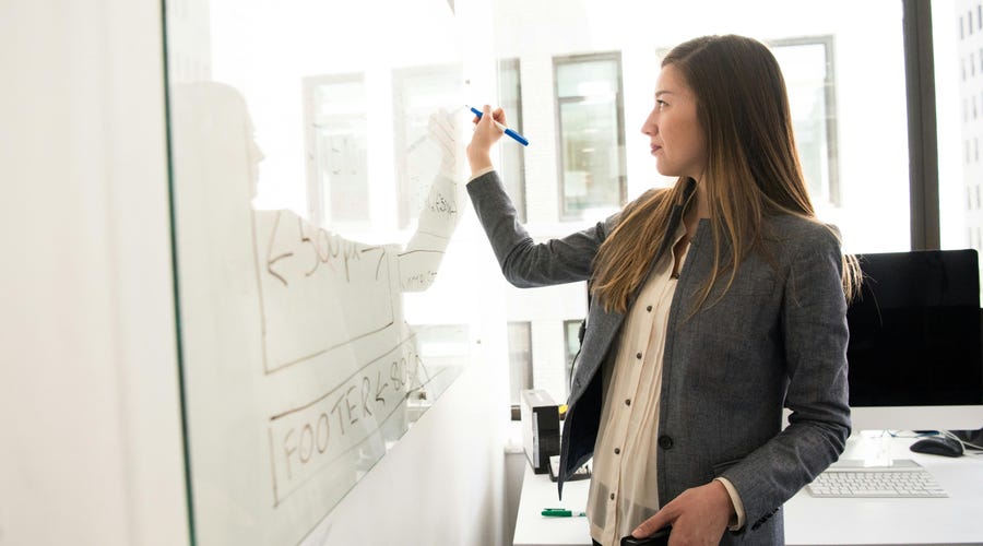 Mulher ensinando termos de comércio exterior em inglês para equipe.