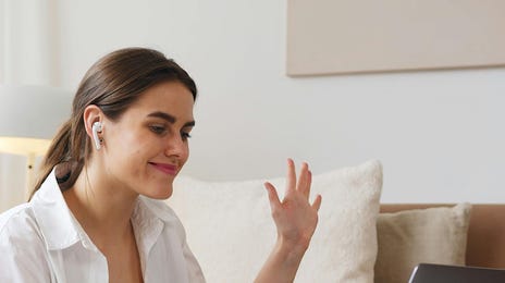Mulher estuda inglês com o Berlitz Flex na sala da sua de casa.
