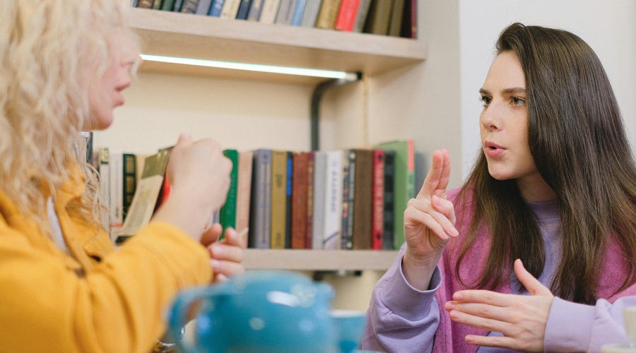 Pessoas utilizando linguagem inclusiva no trabalho.