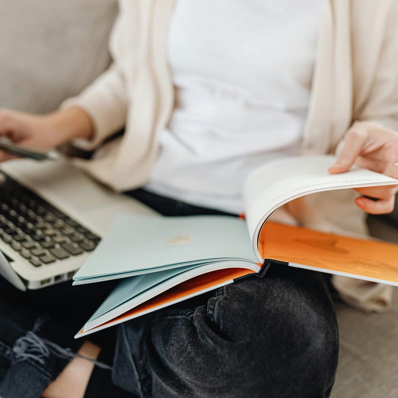 Mulher estudando com um caderno e computador as palavras sem tradução em inglês.