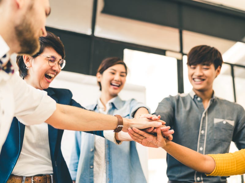 Funcionários com diversidade linguística no trabalho se cumprimentam