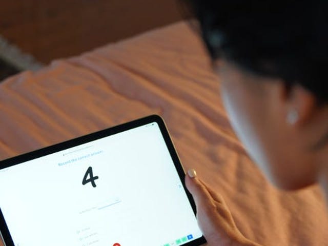 Pessoa vendo um tablet com o número 4 na tela.