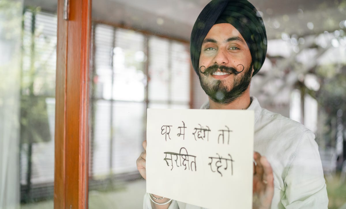 Homem pratica escrita com curso de hindi online.