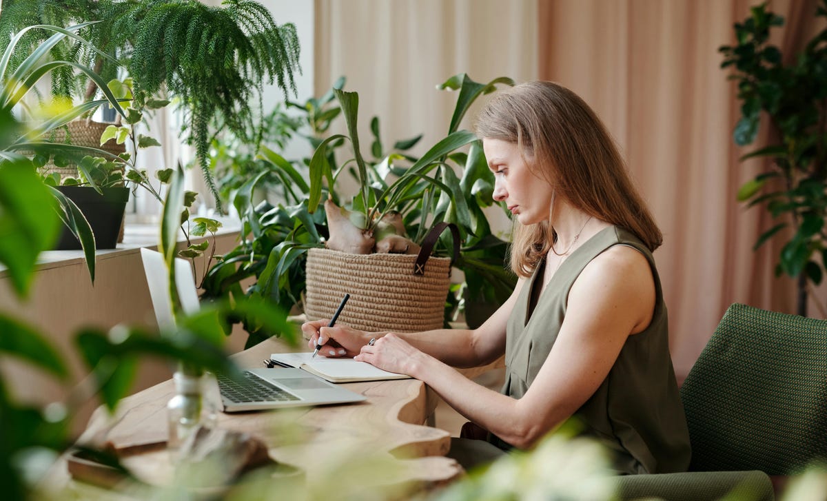 Jovem loira escreve em caderno enquanto estuda para sua aula do curso de alemão no RJ.