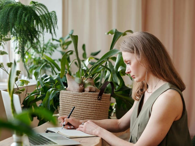 Jovem loira escreve em caderno enquanto estuda para sua aula do curso de alemão no RJ.