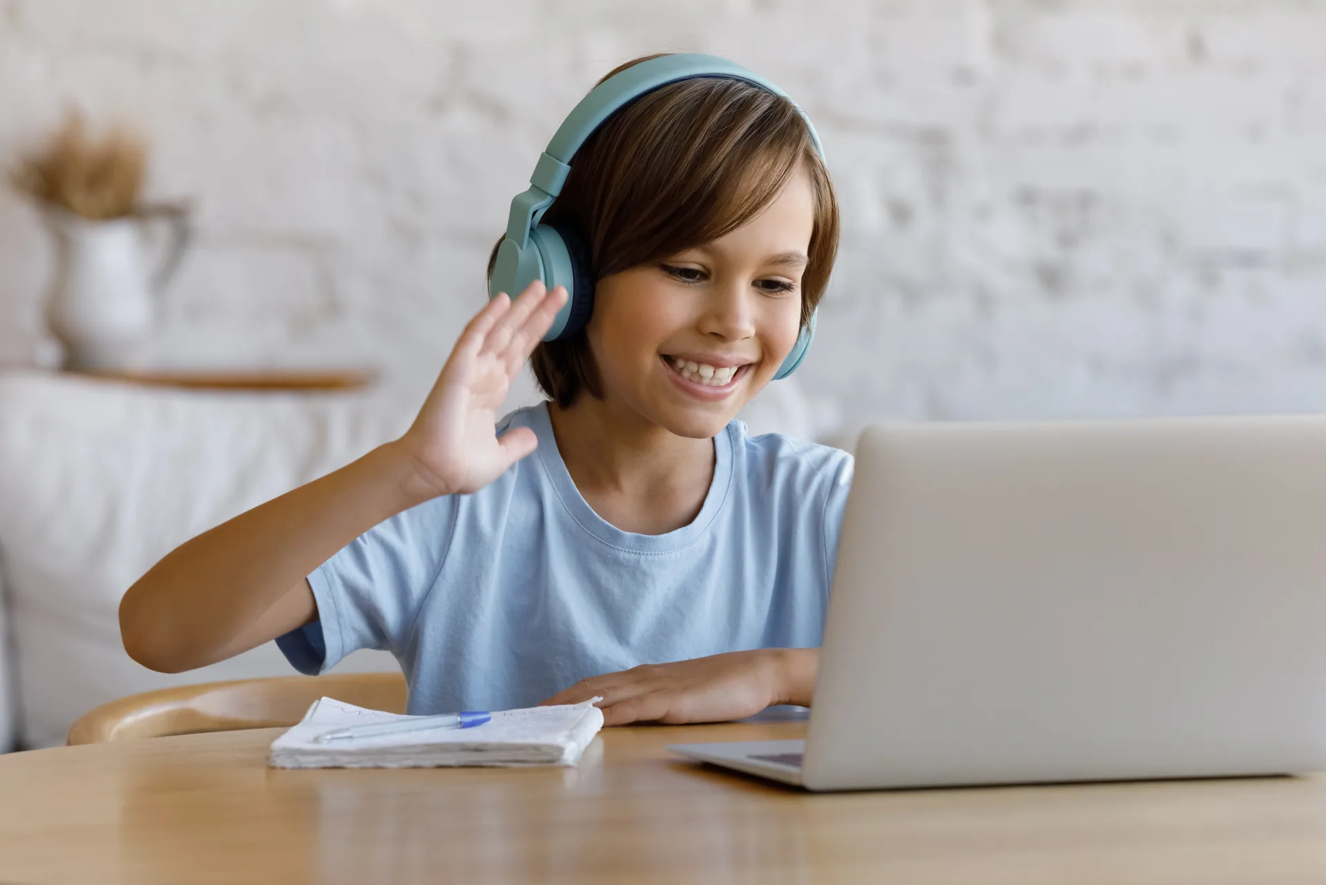 Criança sentada com laptop aprendendo inglês online com a escola de idiomas Berlitz.