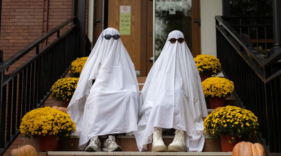Duas pessoas vestidas de fantasmas para celebrar o Halloween
