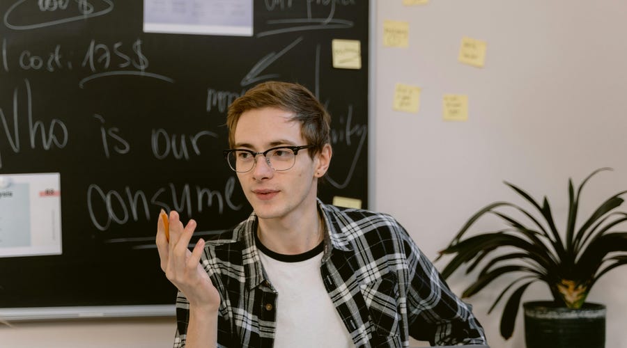 Homem com um computador ensinando a usar as collocations em inglês.