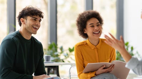 Homem e mulher sentados aprendendo um idioma com o método Berlitz.