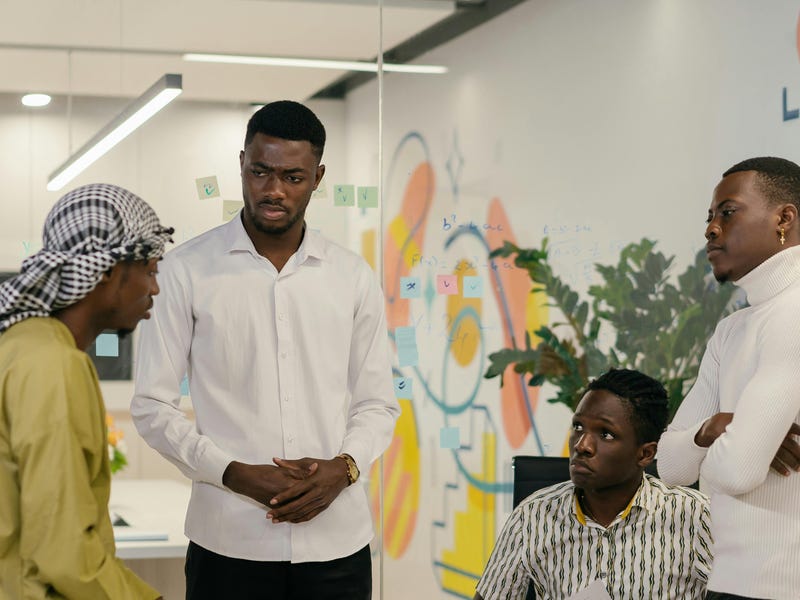 Grupo de quatro homens afrodescendentes falando sobre as línguas africanas.