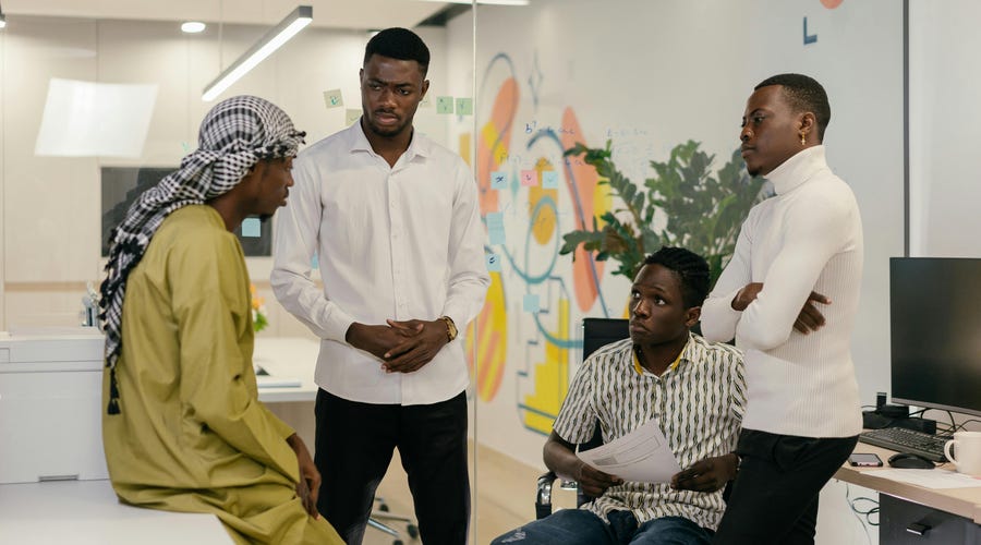 Grupo de quatro homens afrodescendentes falando sobre as línguas africanas.