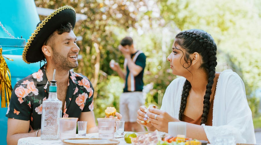 Mulher com tranças e homem usando chapel utilizam termos Tú y usted em espanhol.